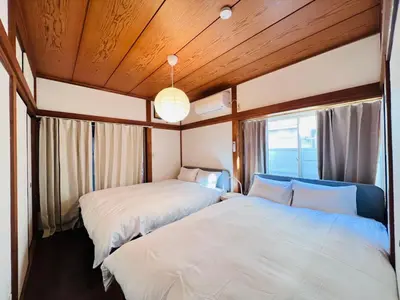 two beds in a room with wooden ceilings at NN-Ōjihonchō-House-KI0174 in Tokyo