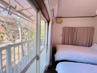 a bedroom with a bed next to a balcony at NN-Ōjihonchō-House-KI0174 in Tokyo
