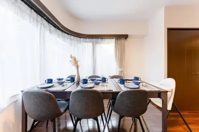 a dining room table with chairs and blue cups and saucers at Villa mitamura301VM31 in Tokyo