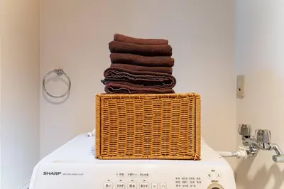 a stack of towels in a basket on top of a washing machine at Villa mitamura301VM31 in Tokyo