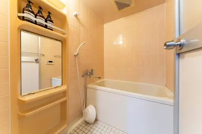 a bathroom with a tub and a toilet and a mirror at Villa mitamura301VM31 in Tokyo