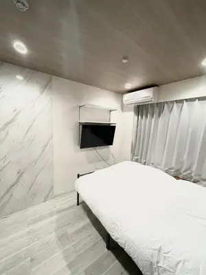 a bedroom with a bed and a flat screen tv at fukuhana \u6771\u65b0\u5bbf2 in Tokyo