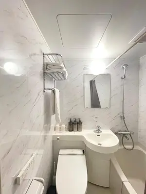 a white bathroom with a toilet and a sink at fukuhana \u6771\u65b0\u5bbf2 in Tokyo