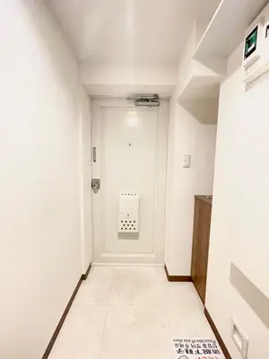 a hallway with a white door and a tile floor at fukuhana \u6771\u65b0\u5bbf2 in Tokyo