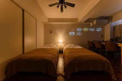 two beds in a room with a light on the wall at Villa mitamura 303 VM33 in Tokyo