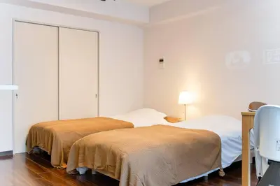 a bedroom with two beds and a desk with a chair at Villa mitamura 303 VM33 in Tokyo