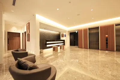 a lobby with two chairs and a piano at Hotel Sunroute Ginza in Tokyo