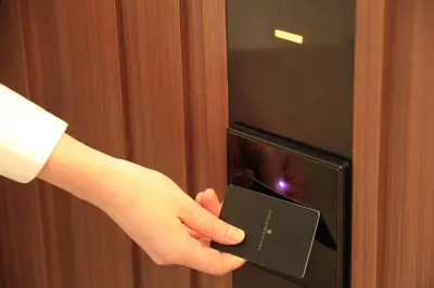 a hand is holding a card in a microwave at Hotel Sunroute Ginza in Tokyo
