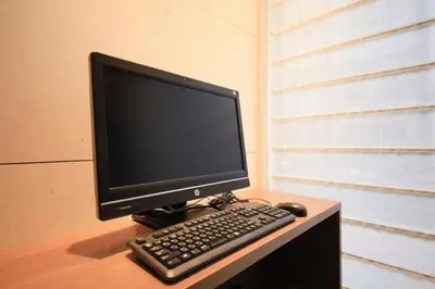a computer monitor and a keyboard and mouse on a desk at Hotel Sunroute Ginza in Tokyo