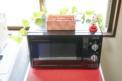 a black microwave on a red counter with a toy at Belmont 303 3min to Station Easy Access Ueno Asakusa Skytree Sleeps 4 in Tokyo