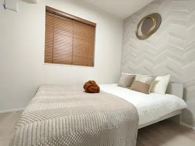 a bedroom with a bed with a brown stuffed animal on it at \u65b0\u5bbf2\u7ad9 \u6c60\u888b\u5168\u65b0\u72ec\u7acb3\u5c42\u522b\u5885 3\u5ba41\u53851\u6d74\u5ba4 \u6700\u59278\u4eba max 8P \u8f66\u7ad97\u5206\u949f 7mins to ST \u94f6\u5ea7 \u65b0\u5bbf \u6d89\u8c37 \u6c60\u888b \u4e1c\u4eac\u76f4\u901a in Tokyo