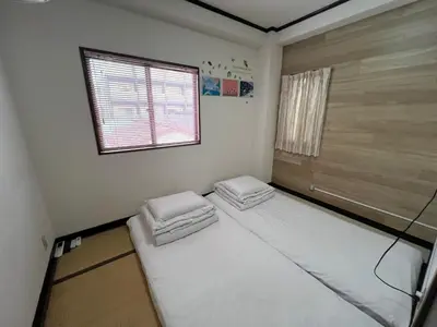 a room with two beds in it with a window at Sky sweet home in Tokyo