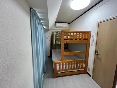 a small room with two bunk beds and a door at Sky sweet home in Tokyo