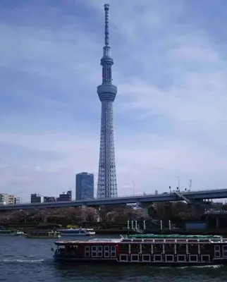 a boat in the water with a tower in the background at Sky sweet home in Tokyo