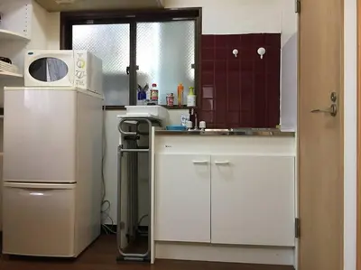 a small kitchen with a sink and a microwave at Sky sweet home in Tokyo
