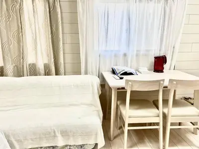 a room with a bed and a table and chairs at Sky sweet home in Tokyo
