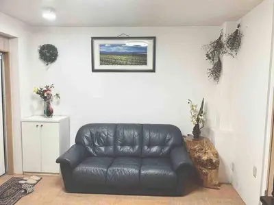 a black leather couch in a living room with a picture at Japanese-style house detached house in Tokyo
