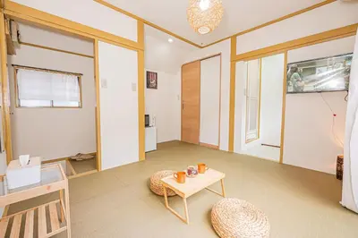a living room with a table and a chair at sunrise 2 in Tokyo