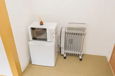 a microwave on top of a refrigerator next to a radiator at sunrise 2 in Tokyo