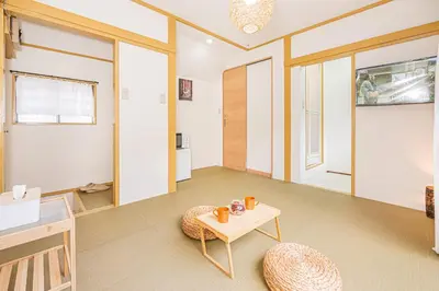 a living room with a table and a chair at sunrise 2 in Tokyo