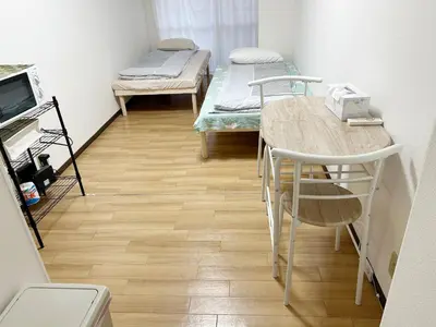 a room with two beds and a table and chairs at \u65b0\u5bbf\u4e2d\u5fc3#\u6b4c\u821e\u4f0e#Shinjuku 3min walk#\u5730\u94c1\u7ad9\u6b65\u884c3\u5206#JR\u65b0\u5bbf\u7ad9\u6b65\u884c9\u5206\u949f#\u97e9\u56fd\u57ce#\u9ad8\u901f\u65e0\u9650\u5236\u7f51\u8def#\u81ea\u52a8Autolock\u5927\u95e8411 in Tokyo
