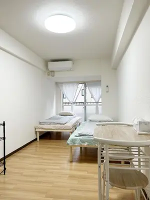 a room with two beds and a table at \u65b0\u5bbf\u4e2d\u5fc3#\u6b4c\u821e\u4f0e#Shinjuku 3min walk#\u5730\u94c1\u7ad9\u6b65\u884c3\u5206#JR\u65b0\u5bbf\u7ad9\u6b65\u884c9\u5206\u949f#\u97e9\u56fd\u57ce#\u9ad8\u901f\u65e0\u9650\u5236\u7f51\u8def#\u81ea\u52a8Autolock\u5927\u95e8411 in Tokyo
