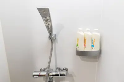 a bathroom with a shower with four toothbrushes at Harebare apartment for max 3ppl 3mins walk from Kiba station 2F in Tokyo