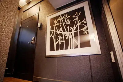 a picture of a tree on a wall next to a door at Harebare apartment for max 3ppl 3mins walk from Kiba station 2F in Tokyo