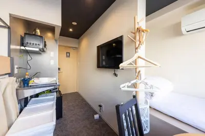 a room with a bed and a kitchen with hangers at Harebare apartment for max 3ppl 3mins walk from Kiba station 2F in Tokyo