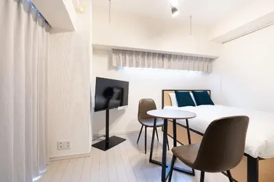 a bedroom with a bed and a table and chairs at PL Park Lane\u767d\u91d1\u9ad8\u8f2a in Tokyo