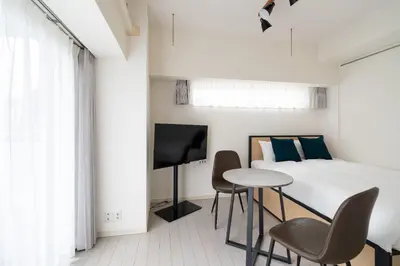 a bedroom with a bed and a table and chairs at PL Park Lane\u767d\u91d1\u9ad8\u8f2a in Tokyo