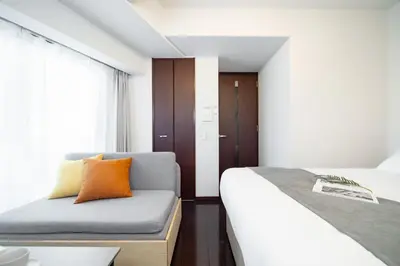 a small bedroom with two beds and a window at PL Park Lane\u767d\u91d1\u9ad8\u8f2a in Tokyo