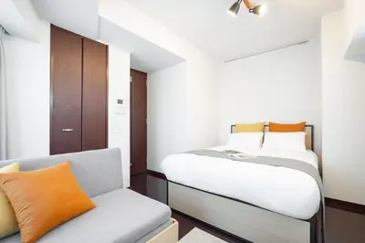 a small bedroom with a bed and a chair at PL Park Lane\u767d\u91d1\u9ad8\u8f2a in Tokyo