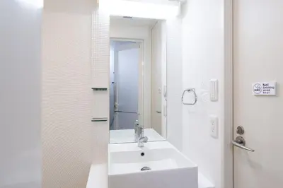 a white bathroom with a sink and a mirror at PL Park Lane\u767d\u91d1\u9ad8\u8f2a in Tokyo