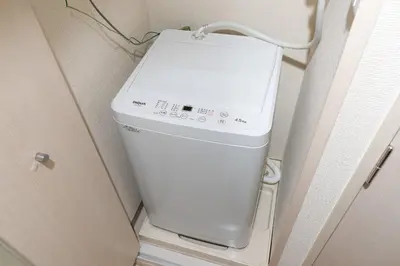 a washing machine in a room with a door at \u30ac\u30fc\u30e9\u30d7\u30ec\u30a4\u30b9\u9326\u7cf8\u753a in Tokyo
