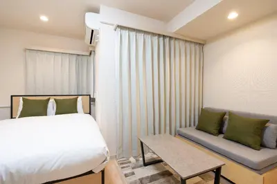 a small bedroom with a bed and a couch at \u30ac\u30fc\u30e9\u30d7\u30ec\u30a4\u30b9\u9326\u7cf8\u753a in Tokyo