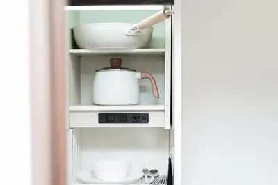 a refrigerator door open with a tea pot and dishes at MX House - Cozy APT Stay in Ikebukuro Tokyo, with Direct Access to Shinjuku & Shibuya in Tokyo
