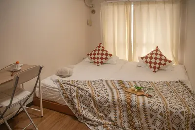 a bedroom with a bed with a desk and a window at Nakano106,Nakano Broadway,Shinjuku 1 stop in Tokyo