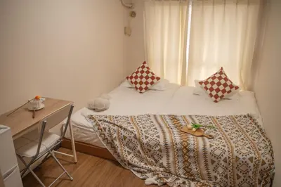 a bedroom with a bed with a desk and a window at Nakano106,Nakano Broadway,Shinjuku 1 stop in Tokyo