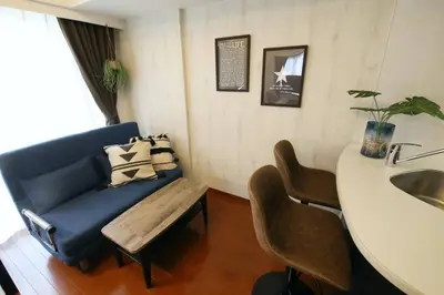 a living room with a blue couch and a bench at Gaia Kabukicho 301 \u30ac\u30a4\u30a2\u6b4c\u821e\u4f0e\u753a in Tokyo