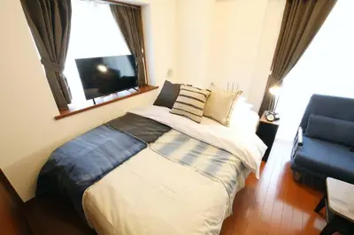 a bedroom with a bed and a window and a television at Gaia Kabukicho 301 \u30ac\u30a4\u30a2\u6b4c\u821e\u4f0e\u753a in Tokyo