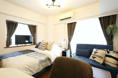 a bedroom with a bed and a couch and a tv at Gaia Kabukicho 301 \u30ac\u30a4\u30a2\u6b4c\u821e\u4f0e\u753a in Tokyo