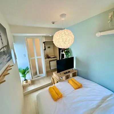 a bedroom with a bed with two yellow pillows at PLAZA SINJUKU Cozy Mansion in Tokyo