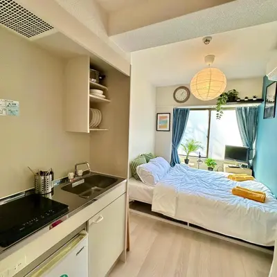 a small room with a bed and a sink at PLAZA SINJUKU Cozy Mansion in Tokyo