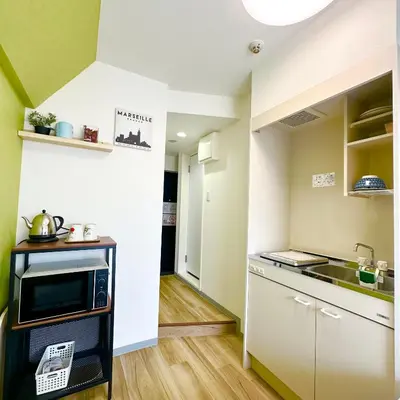 a small kitchen with a sink and a microwave at PLAZA SINJUKU Cozy Mansion in Tokyo