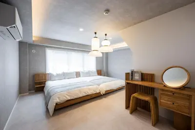 a bedroom with a large white bed and a mirror at WABI & GIVE Nakano Araiyakushi in Tokyo