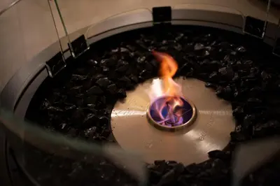 a fire in a metal bowl with rocks at WABI & GIVE Nakano Araiyakushi in Tokyo