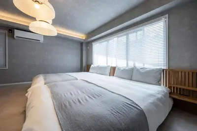 a bedroom with a large bed with a large window at WABI & GIVE Nakano Araiyakushi in Tokyo