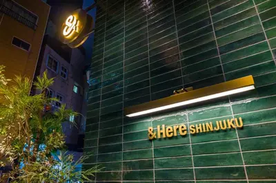 a building with a sign on the side of it at &Here SHINJUKU in Tokyo