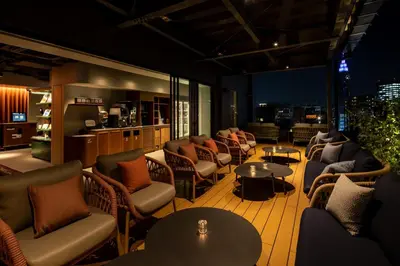a bar with chairs and tables in a room at &Here SHINJUKU in Tokyo